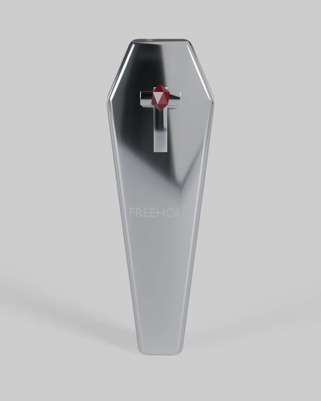 A polished chrome toe-pincher coffin sculpture with a chrome cross and a red gem, engraved FREEHOLD.
