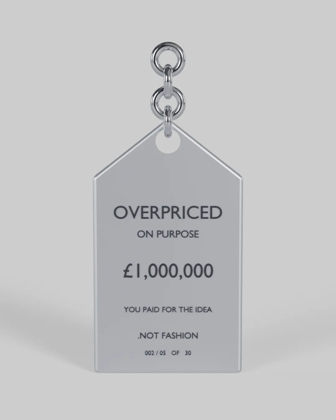 A chrome price-tag sculpture engraved OVERPRICED ON PURPOSE.